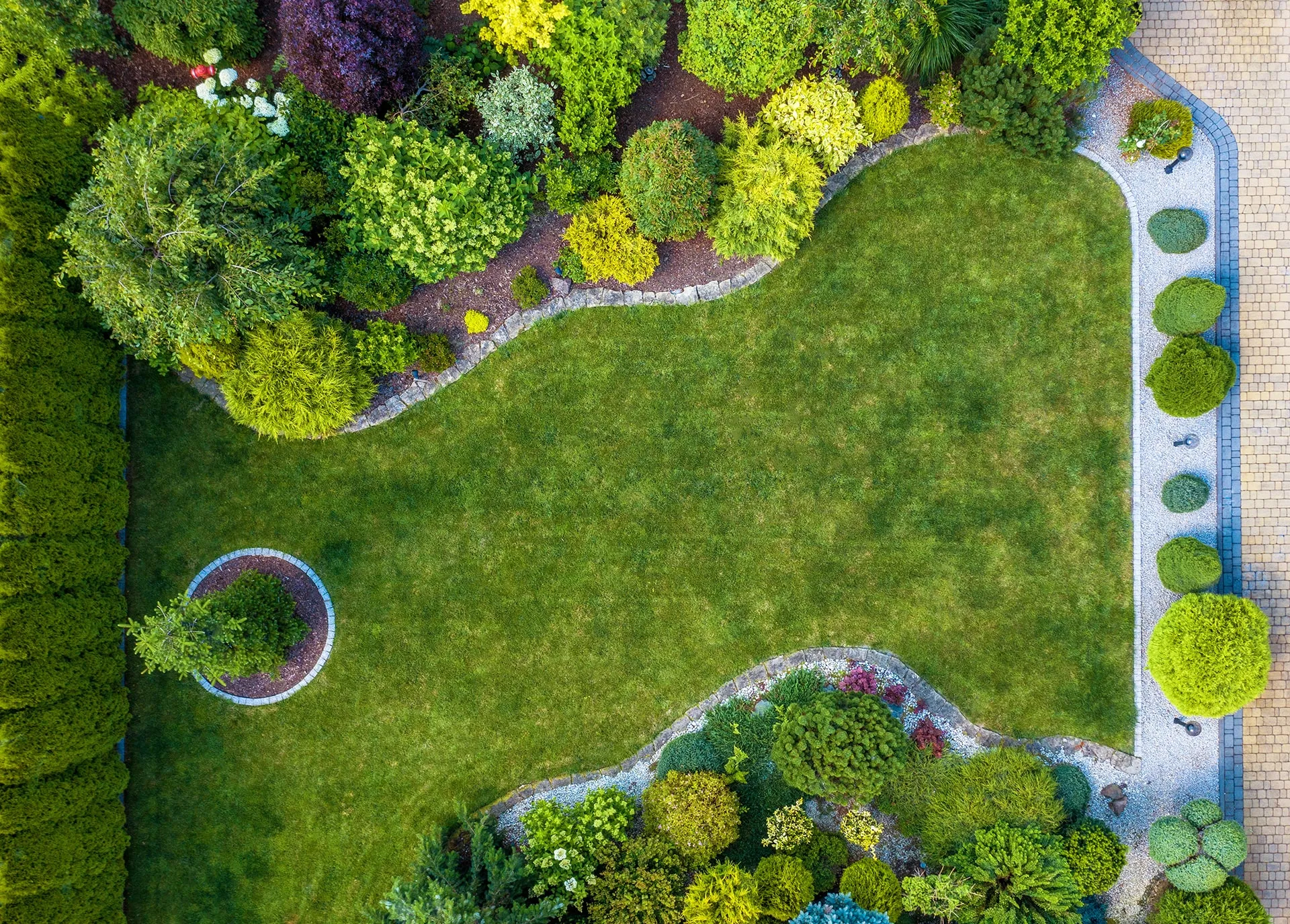Luchtfoto van een ontworpen tuin met glooiend gazon, borders en siergrassen